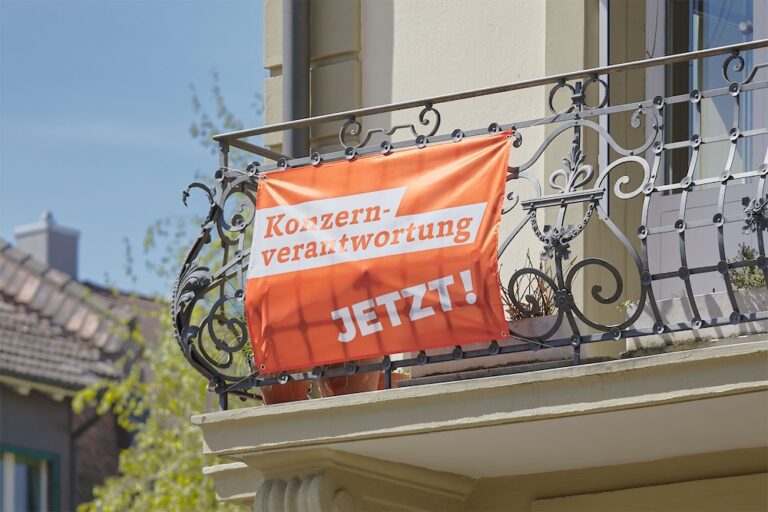 Banner an Balkon zur Konzernverantwortungsinitiative 2025